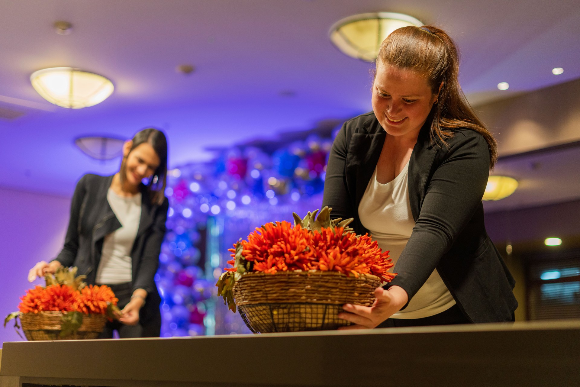 Co-workers make flower arrangements for the party